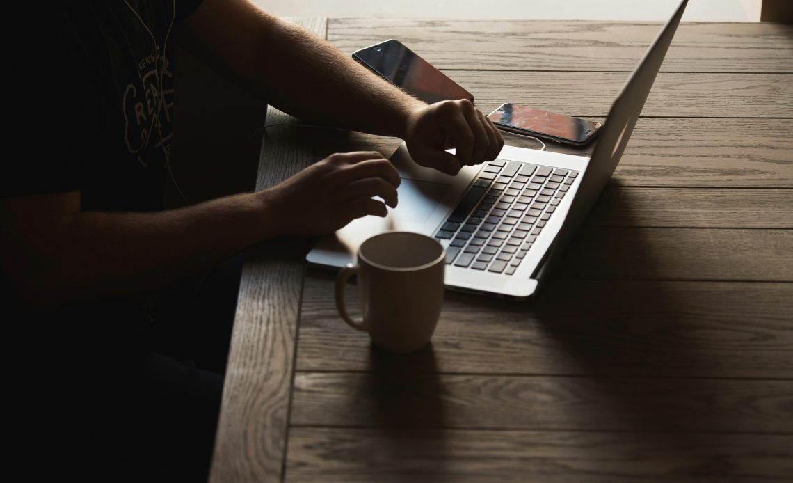 a person researching service mesh vs API gateway on a white laptop