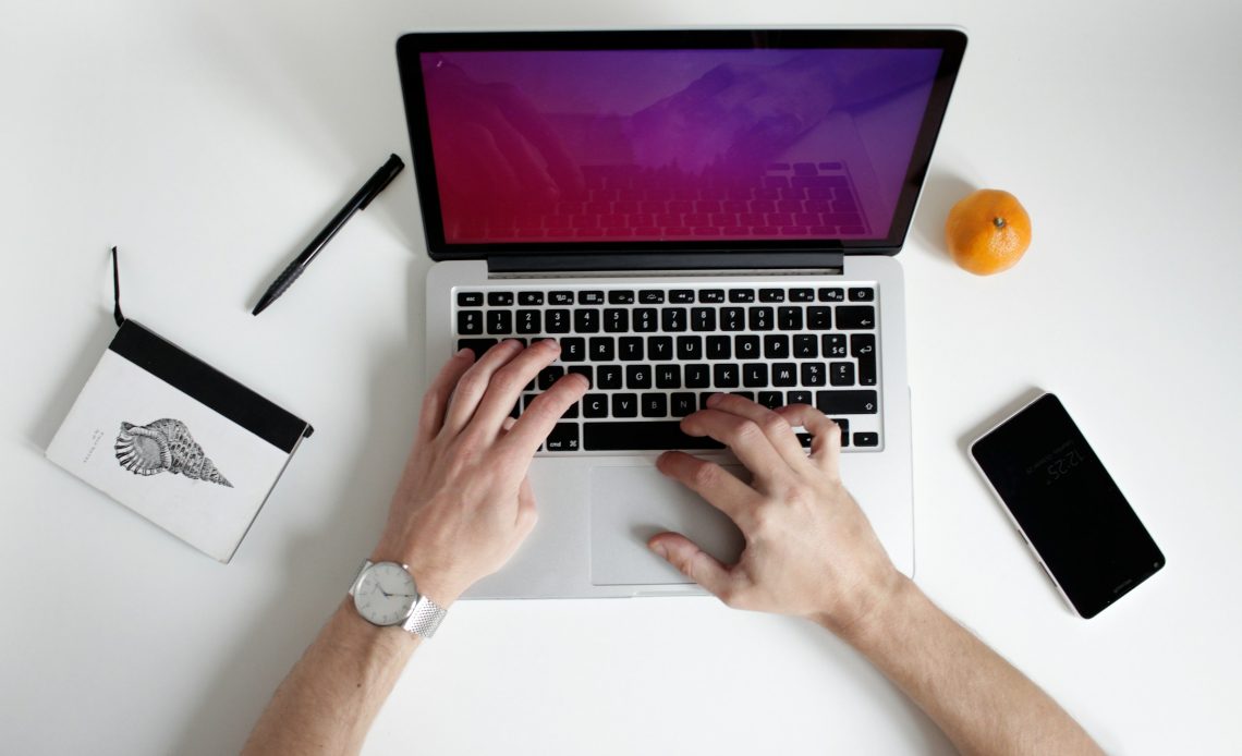 a person researching the unique benefits of api services on a white background with a white laptop